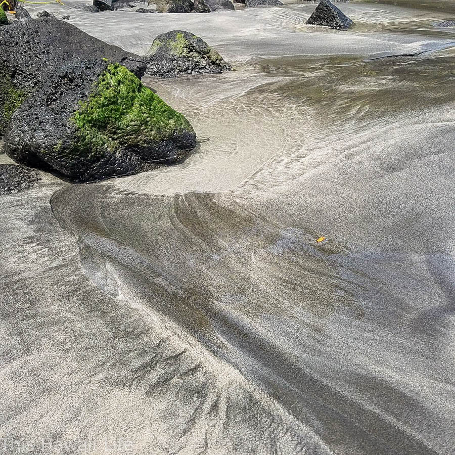 Black and grey sands create patterns at Ha'ena beach Big Island